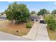 Landscaped front yard with mature trees, shrubs, and long driveway leading to the home at 1114 Hickory Rd, Ocala, FL 34472