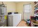 Functional laundry room featuring a washer, dryer, and water heater at 1114 Hickory Rd, Ocala, FL 34472