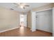Bright bedroom featuring wood floors, ceiling fan, neutral walls and a walk-in closet ready for personalization at 13425 Sw 106Th Pl, Dunnellon, FL 34432