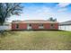 Back exterior view of home with a fenced yard and a small patio area at 13425 Sw 106Th Pl, Dunnellon, FL 34432