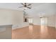 Bright, open living area with ceiling fan, hardwood floors, and seamless flow into kitchen, ideal for entertaining at 13425 Sw 106Th Pl, Dunnellon, FL 34432