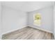 Bright bedroom with light gray walls, wood-look floors, and a window with natural light at 13505 Sw 112 Pl, Dunnellon, FL 34432