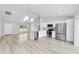 Open-concept living area with sleek floors, modern lighting, and a combined kitchen at 13505 Sw 112 Pl, Dunnellon, FL 34432