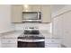 Close up on stainless steel range top and hood in a modern kitchen with gray cabinets at 1598 Sw 152Nd Ct, Ocala, FL 34481