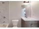Bathroom with marble tiled shower over tub, white toilet and gray vanity cabinet at 1610 Sw 152Nd Ct, Ocala, FL 34481
