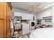 Bright laundry room with front load washer and dryer, sink, overhead storage, and vintage-inspired decor at 17505 Se 100Th Ct, Summerfield, FL 34491