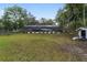 Sprawling backyard with mature trees, screened pool, and fenced perimeter at 1781 Se 85Th Street Rd, Ocala, FL 34480