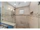 Modern bathroom featuring stone-look tiled walls, mosaic accents, and a frameless glass shower enclosure at 1781 Se 85Th Street Rd, Ocala, FL 34480