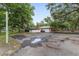 Wide driveway leading to a brick and white home with mature trees and an ATV at 1781 Se 85Th Street Rd, Ocala, FL 34480