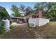 Backyard view with brick chimney, fenced yard, patio, and backup generator at 1781 Se 85Th Street Rd, Ocala, FL 34480