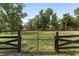 Gated front yard surrounded by trees and grass at 1781 Se 85Th Street Rd, Ocala, FL 34480