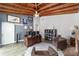 Living area featuring brick fireplace, vaulted wood ceiling, comfortable seating, and an exterior exit at 1781 Se 85Th Street Rd, Ocala, FL 34480