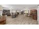 Expansive living area featuring wood-look tile flooring, stone fireplace, dining area and access to modern kitchen at 1781 Se 85Th Street Rd, Ocala, FL 34480