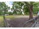 Lush green pasture with scattered trees and a dark wooden fence, offering a serene setting for horses and other animals at 1781 Se 85Th Street Rd, Ocala, FL 34480