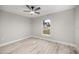 Neutral bedroom features wood-look floors, ceiling fan, and a window with neighborhood views at 20751 Sw Cardinal Ave, Dunnellon, FL 34431