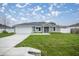 Charming single-story home featuring stone accents, a well-manicured lawn, and a two-car garage at 20751 Sw Cardinal Ave, Dunnellon, FL 34431