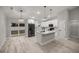 Modern kitchen features white cabinets, a center island with black fixtures, and stainless steel appliances at 20751 Sw Cardinal Ave, Dunnellon, FL 34431