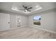 Main bedroom features tray ceiling with fan, adjacent bathroom, and wood-look floors at 20751 Sw Cardinal Ave, Dunnellon, FL 34431