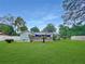Spacious backyard with a deck featuring a pergola, blending outdoor living and serene green space for relaxation and entertaining at 2340 Ne 44Th St, Ocala, FL 34479