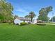 Well-manicured lawn surrounds this charming home with mature trees, showcasing the property's peaceful setting and curb appeal at 2340 Ne 44Th St, Ocala, FL 34479