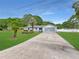 Inviting single-story home with a long driveway, mature trees, and an attached garage offering ample parking and curb appeal at 2340 Ne 44Th St, Ocala, FL 34479