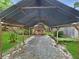 Covered shed with gravel floor in a spacious backyard, providing practical storage and blending with the natural landscape at 2340 Ne 44Th St, Ocala, FL 34479