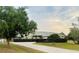 Charming single-story home with a well-manicured lawn, concrete driveway, and lush green landscaping at 2910 Ne 24Th Pl, Ocala, FL 34470