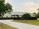 Charming single-story home with a well-manicured lawn, concrete driveway, and lush green landscaping at 2910 Ne 24Th Pl, Ocala, FL 34470