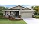 Charming single-story home with neutral siding, well-manicured lawn, and a two-car garage at 3076 Canopy Oak Blvd, Wildwood, FL 34785