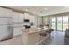 Open kitchen with granite island, stainless appliances, and sliding glass doors to backyard at 3076 Canopy Oak Blvd, Wildwood, FL 34785