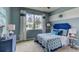 A lovely bedroom featuring a blue color scheme, a bright window, and tasteful furnishings at 3080 Canopy Oak Blvd, Wildwood, FL 34785
