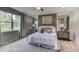 Primary bedroom features a king bed, mirrored closet doors, and an en-suite bathroom at 3080 Canopy Oak Blvd, Wildwood, FL 34785