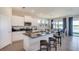 Open-concept kitchen with stainless steel appliances, granite countertops, and a breakfast bar at 3080 Canopy Oak Blvd, Wildwood, FL 34785