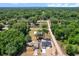This aerial view showcases both homes and large storage building surrounded by luscious green space at 3112 Se 140Th Ln, Summerfield, FL 34491