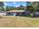 The house backyard with mature trees, offers plenty of space for outdoor activities at 3112 Se 140Th Ln, Summerfield, FL 34491