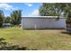 A large barn on a grassy lot, providing ample storage space or potential for various uses at 3112 Se 140Th Ln, Summerfield, FL 34491