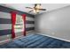 Bedroom featuring a blue bedspread and striped walls with a ceiling fan at 3112 Se 140Th Ln, Summerfield, FL 34491