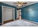 Bedroom featuring a closet and a ceiling fan with blue walls and wood floors at 3112 Se 140Th Ln, Summerfield, FL 34491