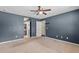 Large bedroom with ceiling fan and two doorways, carpeted with ample space and natural light at 3112 Se 140Th Ln, Summerfield, FL 34491