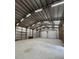 Spacious workshop area with metal walls, storage racks and two large garage doors at 3112 Se 140Th Ln, Summerfield, FL 34491