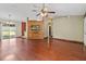 Open concept living room with hardwood floors, ceiling fan, and a partial wood wall at 3112 Se 140Th Ln, Summerfield, FL 34491