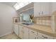 The kitchen has stainless sink, white cabinets, and view to the living area at 3449 Sw 19Th St, Ocala, FL 34474