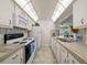 Bright kitchen featuring white appliances, countertops, and a stainless steel double sink with a view of the living space at 3449 Sw 19Th St, Ocala, FL 34474