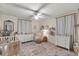 Well-lit bedroom with neutral tones, ceiling fan, dresser, and cozy decor at 400 Se 45Th Ter, Ocala, FL 34471