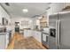 Kitchen featuring stainless appliances, tile backsplash and white cabinets with black hardware at 400 Se 45Th Ter, Ocala, FL 34471