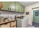 Laundry room featuring modern washer and dryer with green cabinetry at 400 Se 45Th Ter, Ocala, FL 34471