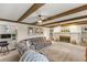 Open living room featuring a comfortable couch, brick fireplace, and hardwood beam ceiling at 400 Se 45Th Ter, Ocala, FL 34471