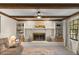 Bright living room with exposed beam ceiling, a white brick fireplace, and built-in shelving at 400 Se 45Th Ter, Ocala, FL 34471