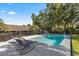 Inviting pool area featuring lounge chairs, shade trees, and secure fencing creating a private backyard oasis at 400 Se 45Th Ter, Ocala, FL 34471