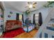 Charming bedroom with playful decor, including a crib, playpen, and hardwood flooring at 408 Etheredge St, Bushnell, FL 33513